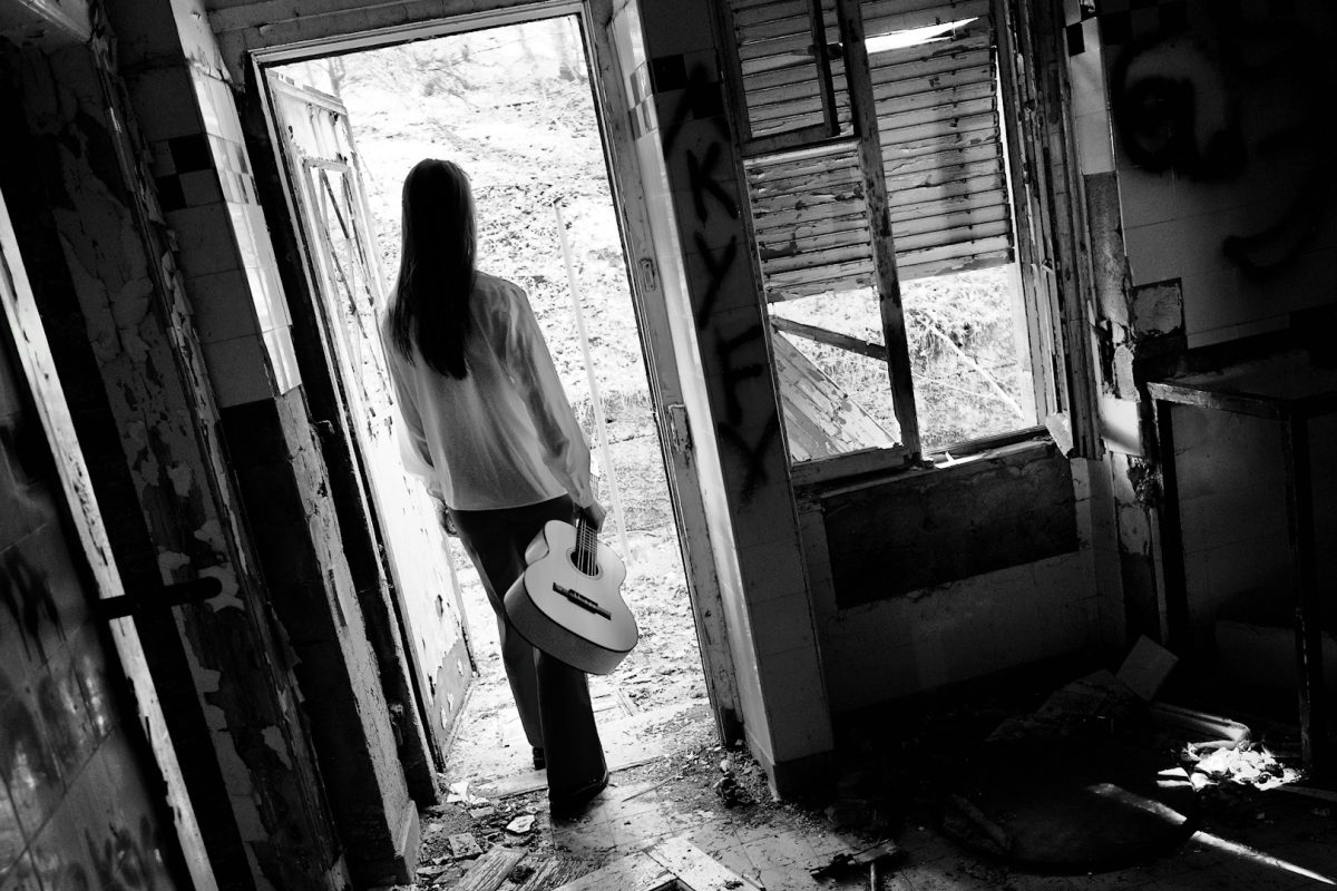 Person walking out of an abandoned, decaying house — symbolizing an unsold home