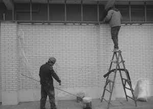Worker standing on a ladder against a brick wall symbolizing business growth built on borrowed access.